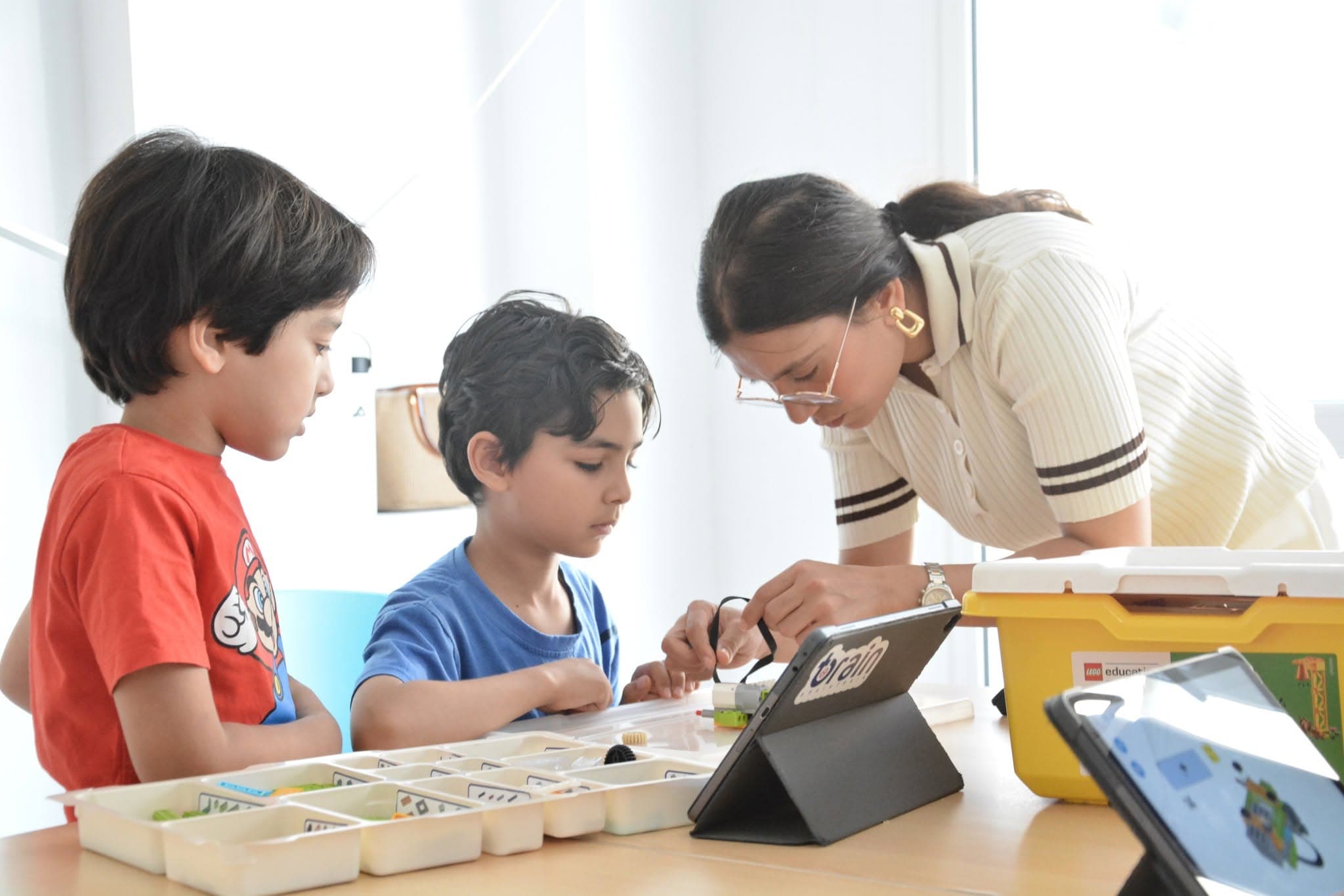 Des élèves de BrainTrain collaborant autour d'un tableau blanc